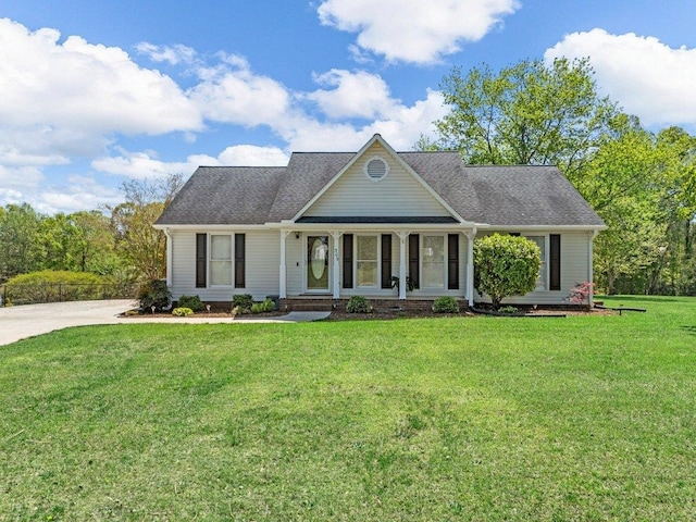 view of front of home with covered porch, a front yard, and concrete driveway