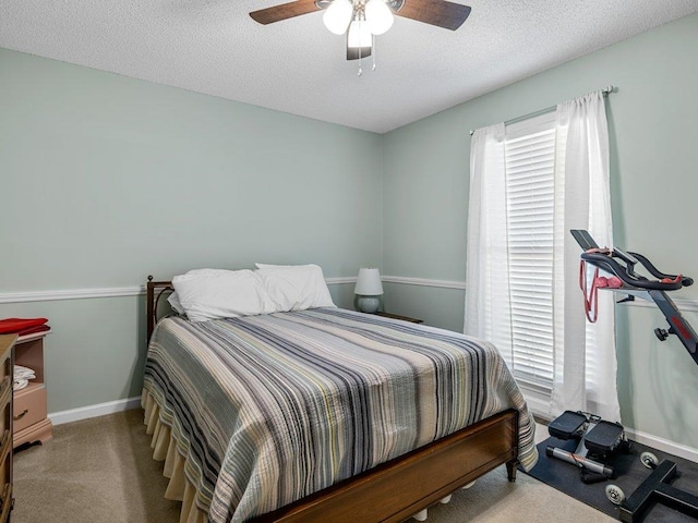 bedroom featuring carpet flooring, a textured ceiling, baseboards, and ceiling fan