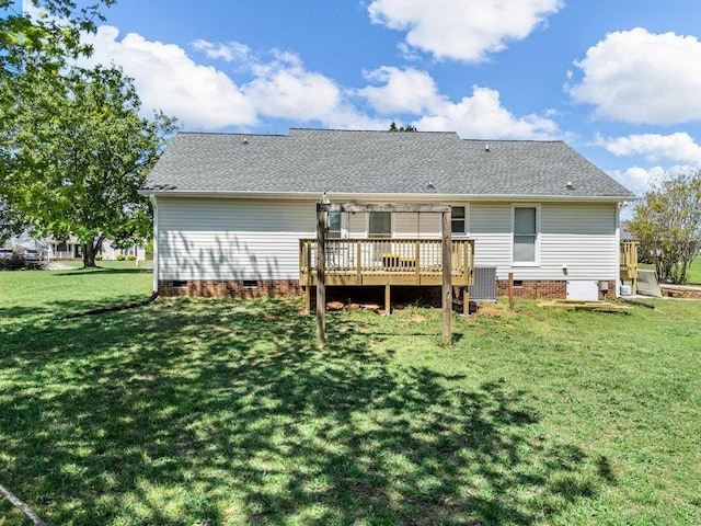 back of property featuring roof with shingles, a wooden deck, a yard, and crawl space