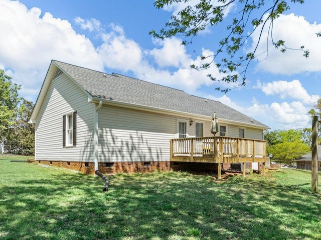 back of property with a wooden deck, a shingled roof, a yard, and crawl space