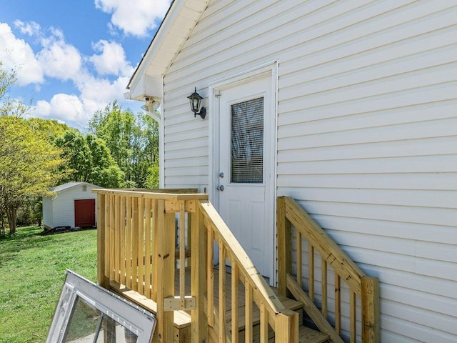 doorway to property with a lawn and a wooden deck