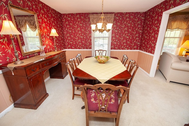 dining room with wallpapered walls, a chandelier, and wainscoting