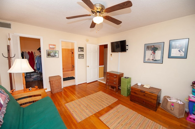 interior space featuring baseboards, ceiling fan, wood finished floors, and visible vents