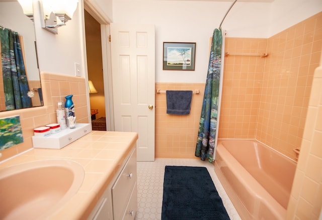 full bath featuring shower / bath combo, tile walls, a wainscoted wall, and vanity