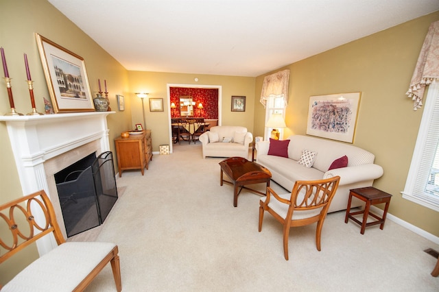 living area with a fireplace with flush hearth, baseboards, and carpet flooring