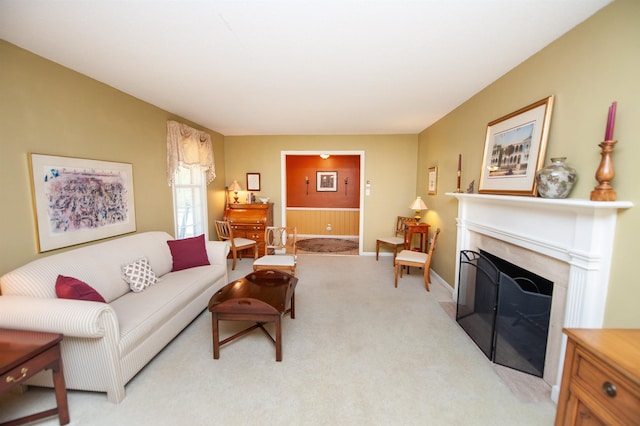 living room with baseboards, a fireplace with flush hearth, and light carpet