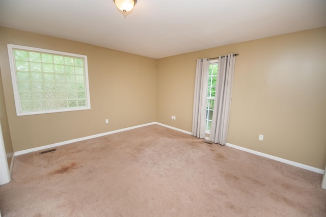 carpeted spare room with baseboards and visible vents