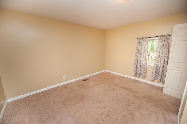 empty room featuring baseboards, carpet floors, and visible vents