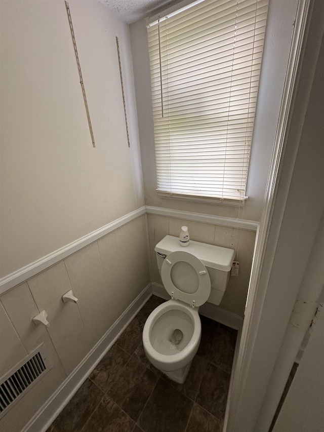 bathroom with tile patterned floors, toilet, and visible vents