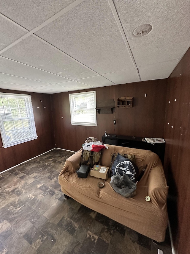 bedroom with wood walls, a wall mounted AC, and multiple windows