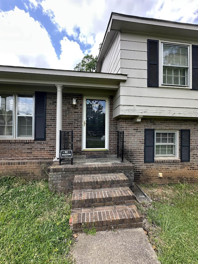 view of exterior entry featuring brick siding