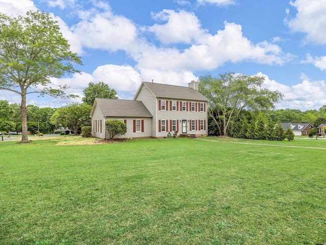 view of front of home featuring a chimney and a front lawn