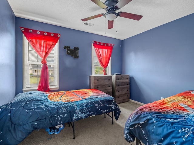 carpeted bedroom with a ceiling fan, a textured ceiling, and visible vents