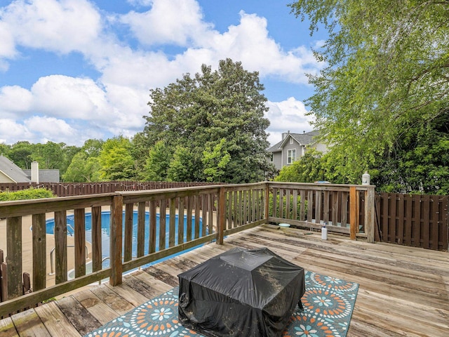 wooden deck with fence and an outdoor pool