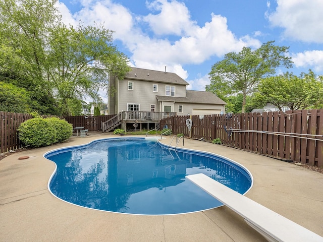 view of swimming pool featuring a diving board, a deck, a fenced backyard, a fenced in pool, and a patio