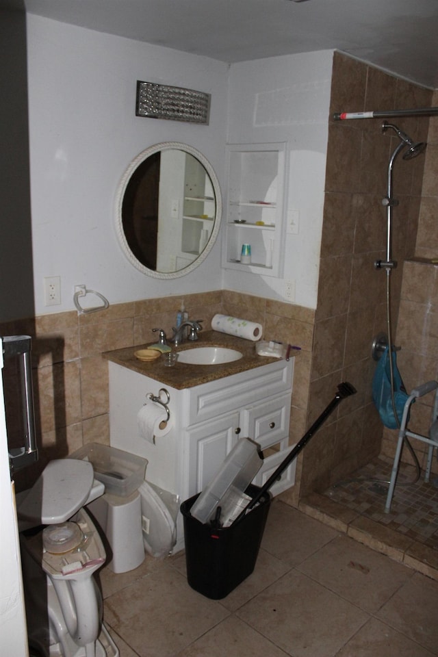 bathroom with vanity, tile walls, and a tile shower