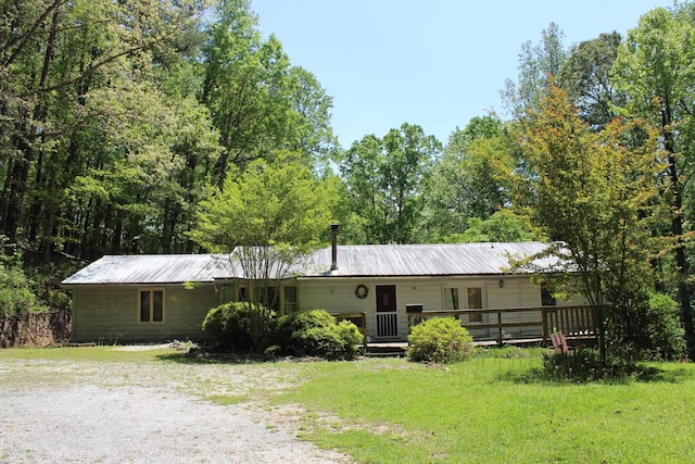 view of front of home with metal roof and a front lawn