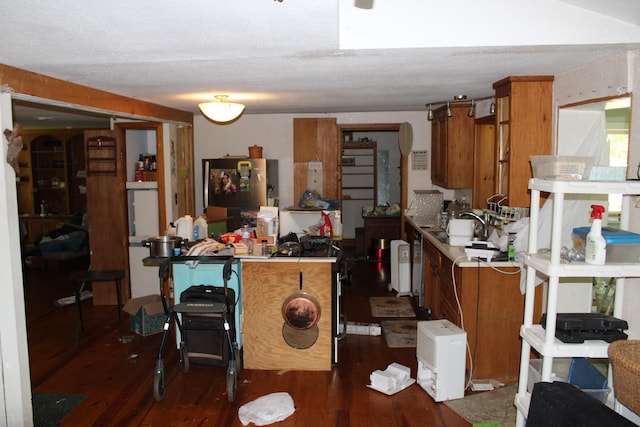 interior space featuring dark wood finished floors, light countertops, freestanding refrigerator, and brown cabinets