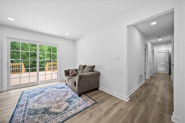 living area featuring baseboards, attic access, wood finished floors, and recessed lighting