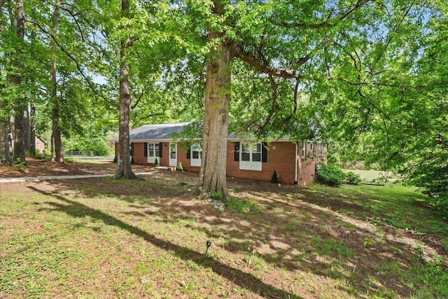 view of front of house featuring brick siding and a front yard