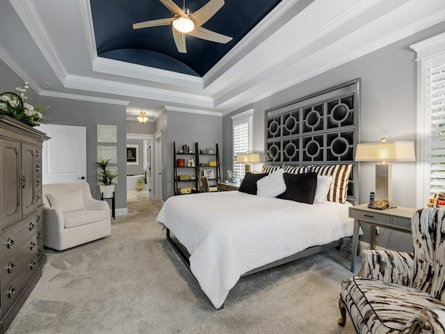 bedroom with ornamental molding, a tray ceiling, ceiling fan, and light colored carpet