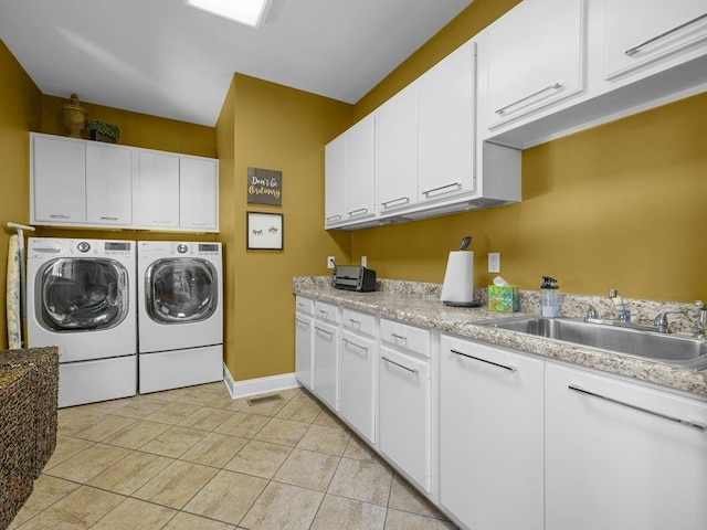 clothes washing area featuring cabinet space, a sink, baseboards, light tile patterned floors, and washer and clothes dryer