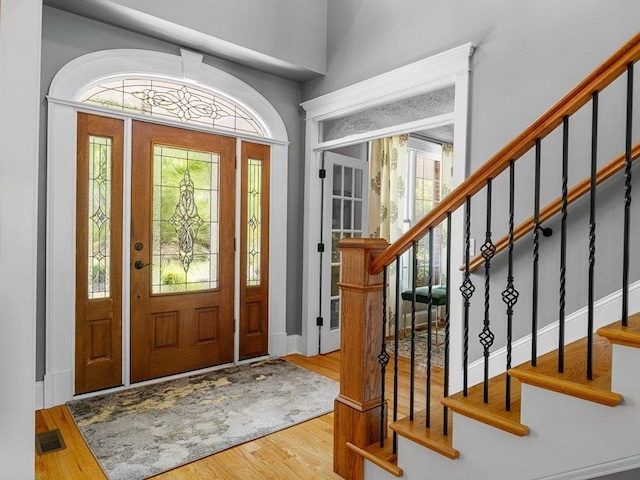 entryway with visible vents, baseboards, stairs, and wood finished floors