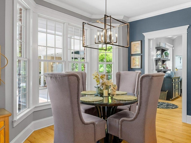 dining area featuring an inviting chandelier, ornamental molding, baseboards, and wood finished floors