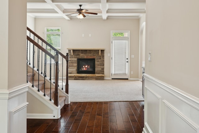entryway featuring a fireplace, ceiling fan, beamed ceiling, and dark wood finished floors