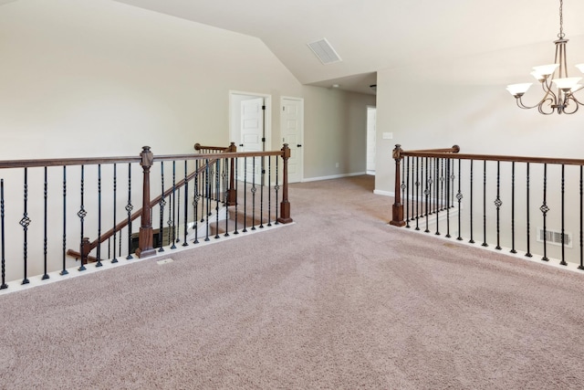 corridor with a notable chandelier, carpet, baseboards, an upstairs landing, and vaulted ceiling