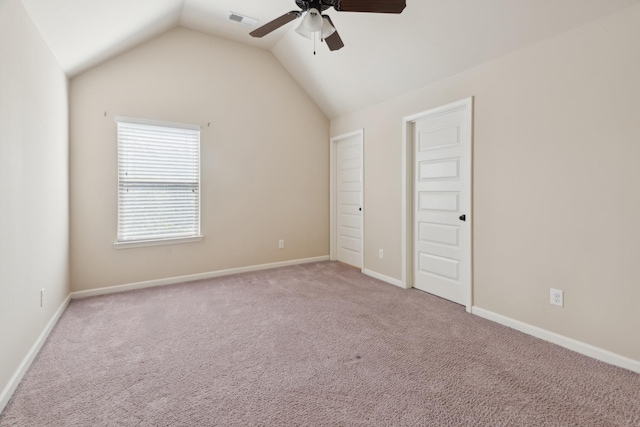 unfurnished bedroom with ceiling fan, carpet floors, baseboards, vaulted ceiling, and visible vents