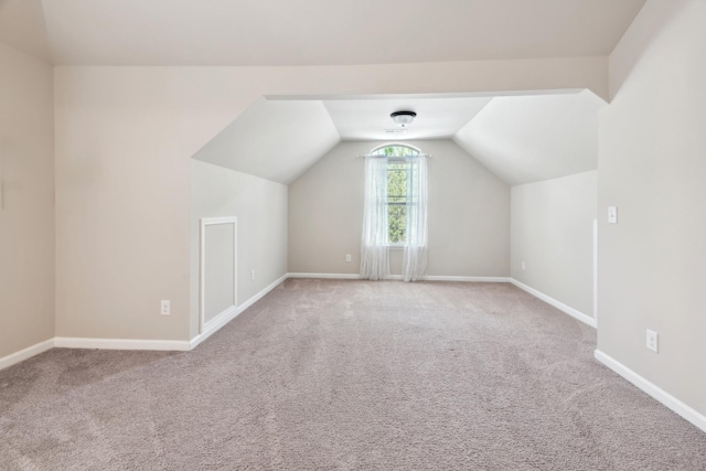 bonus room with baseboards, lofted ceiling, and carpet
