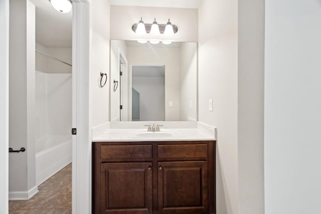 bathroom featuring vanity, baseboards, and bathtub / shower combination
