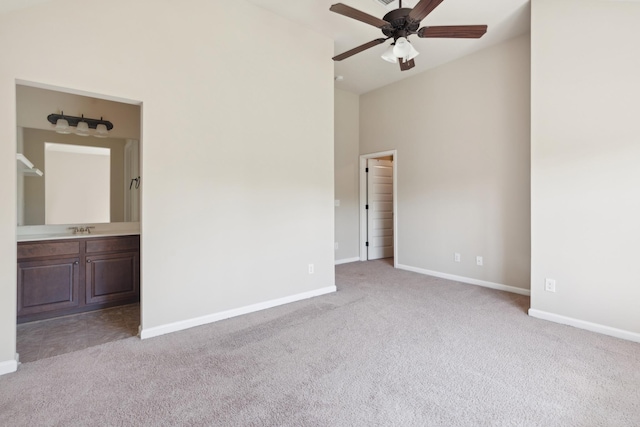 unfurnished bedroom featuring a sink, baseboards, carpet flooring, and ensuite bath