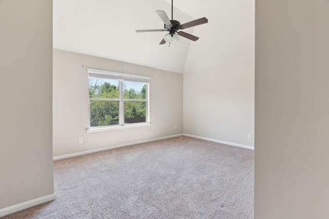 carpeted empty room featuring baseboards, a ceiling fan, and lofted ceiling