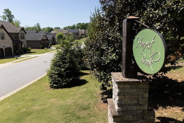 community / neighborhood sign with a residential view and a yard
