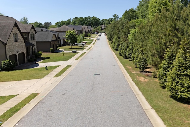 view of road with a residential view and curbs