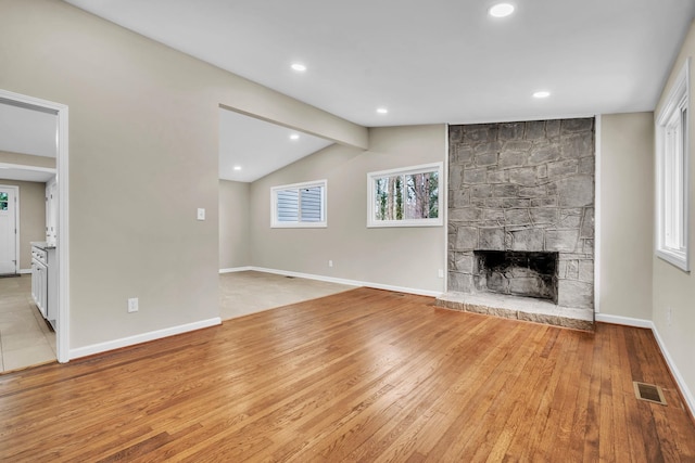 103 Forest Hls, Gaffney, SC 29340 - unfurnished living room featuring visible vents, baseboards, a stone fireplace, vaulted ceiling with beams, and light wood-type flooring