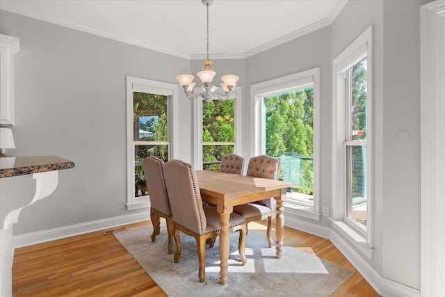 dining space with visible vents, ornamental molding, baseboards, light wood-type flooring, and a notable chandelier