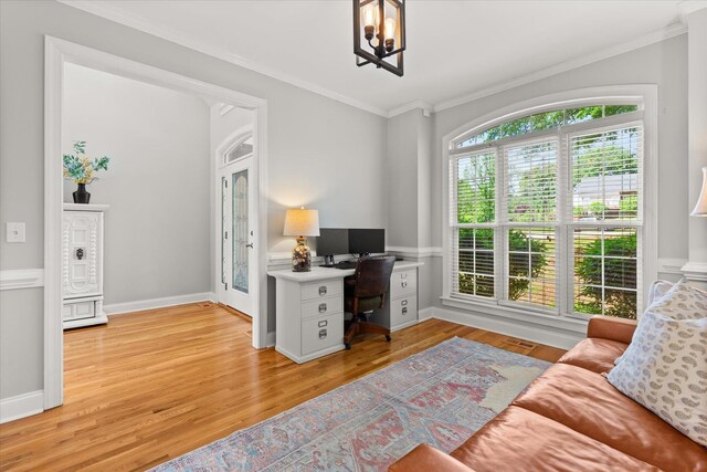 office space featuring an inviting chandelier, ornamental molding, and light wood-style flooring