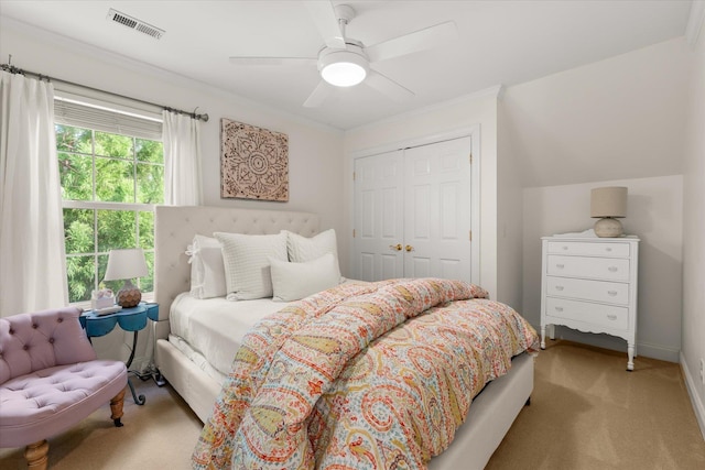 bedroom featuring ceiling fan, visible vents, crown molding, a closet, and carpet