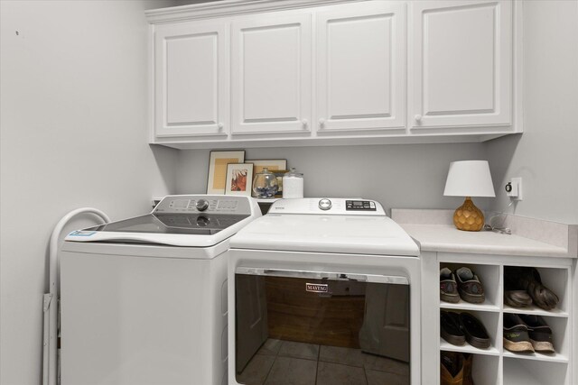 laundry area with cabinet space, tile patterned floors, and washing machine and clothes dryer