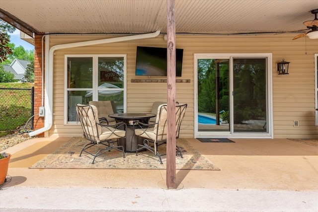 view of patio with ceiling fan and fence