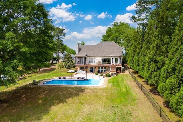 view of swimming pool featuring a wooden deck, a patio area, a fenced backyard, a yard, and stairs