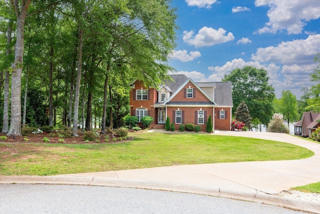 view of front of property with concrete driveway, brick siding, and a front lawn