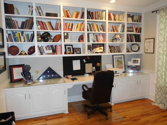 office space with built in study area and light wood-type flooring
