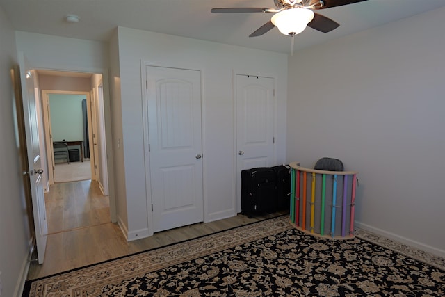 unfurnished bedroom with a ceiling fan, baseboards, and light wood finished floors