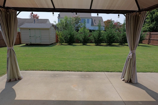 view of yard featuring a patio, an outbuilding, a fenced backyard, and a storage shed