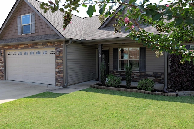 craftsman-style home featuring a garage, a front lawn, covered porch, stone siding, and concrete driveway