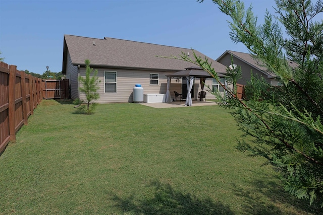 back of property featuring a lawn, a gazebo, a patio area, and a fenced backyard